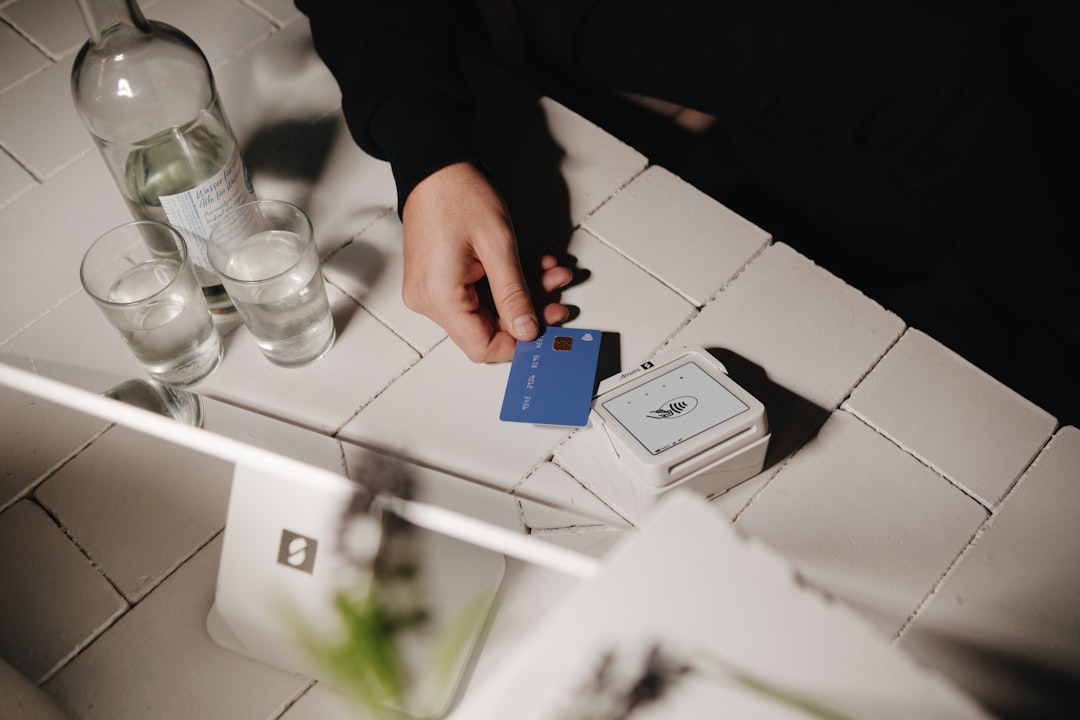 A hand is holding a blue card.